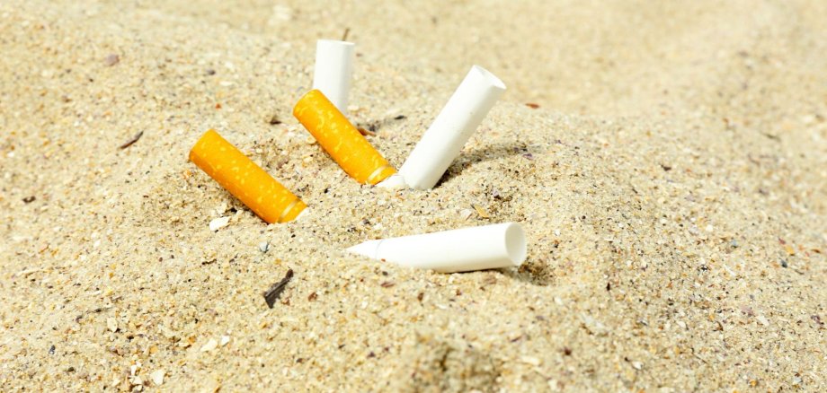 Zigarettenkippen im Sand